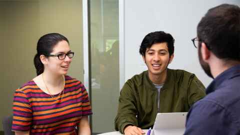 Two students talking to teacher