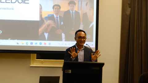 A young man presenting at a lectern.