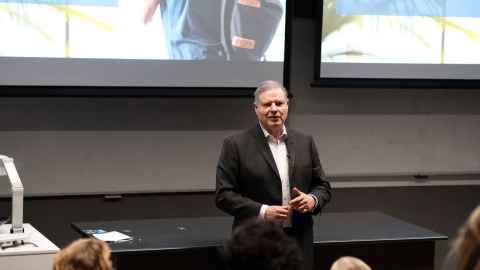 A man in a suit standing at the front of a classroom