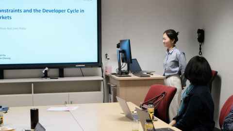 A young Asian woman presenting in a classroom
