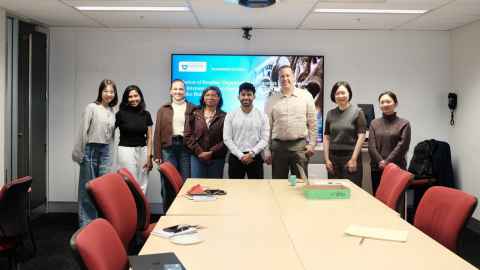 A group of smiling people in a seminar room