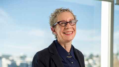 A smiling woman wearing glasses