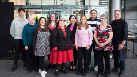 Ten team members of the Student Development and Engagement team facing the camera and smiling.