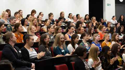 A large group of young women sitting in a lecture theatre.