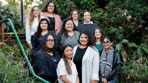 The Te Papa Manaaki team photo with greenery in the background.