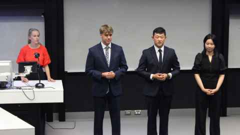 Four students in formal attire presenting in a caseroom.