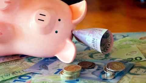Piggy bank with money on the background like coins and notes