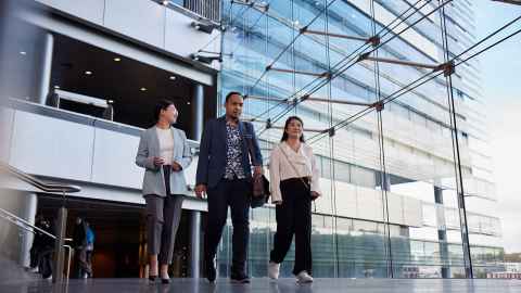 Three postgraduate students walking inside the OGGB