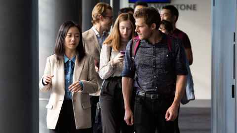Group of students walking along the hallway, chatting