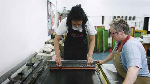 Student and technician working in the printmaking studio on campus.