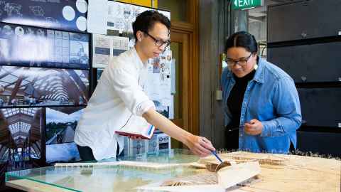 2 students looking at architectural models on desk