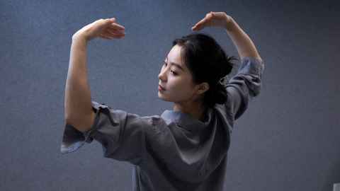 Close up of Ruochen posed mid dance move wearing a grey top