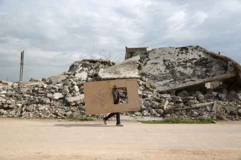 Person walking holding cardboard in Syria