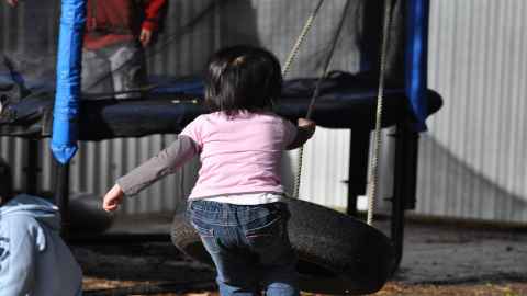 A child runs towards a tyre swing