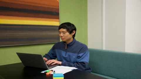Zhixiao Yang sits in front of a computer.