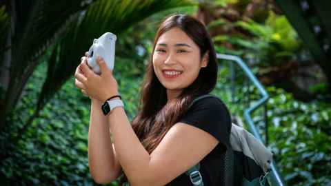 Eden outside surrounded by greenery with a camera