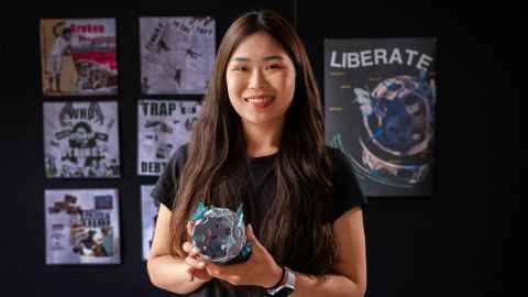 Genyuan standing with her 3D printed model and art work