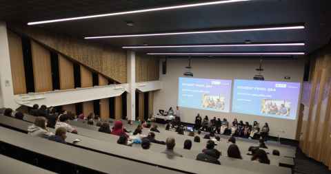 A lecture theatre full of students listening to women in engineering students present