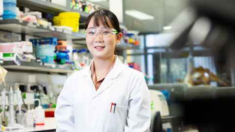 A young woman in a white lab coat.