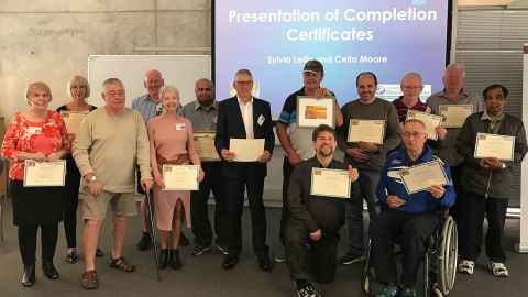 A group of people holding certificates.
