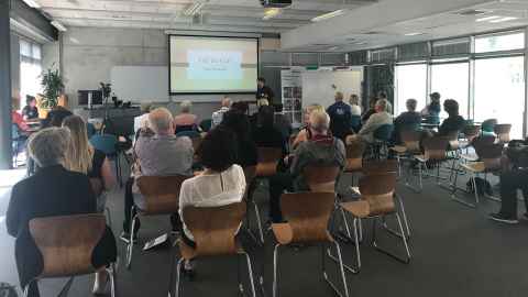 A group of people watching a presentation.