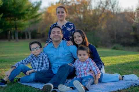 Young family sitting on a picnic blanket outside