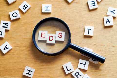 Scrabble tile letters E, D, S with magnifying glass 