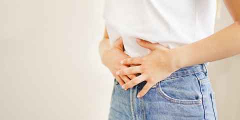 Person holding hands on stomach