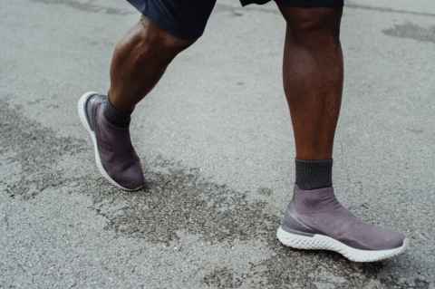 man wearing sneakers walking
