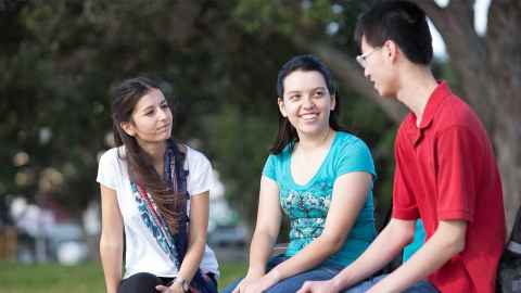 Students sitting outside Faculty of Medical and Health Sciences building.