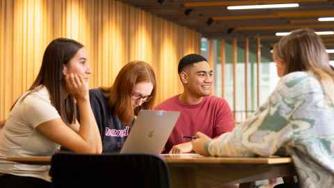 a group of four students sitting at a table