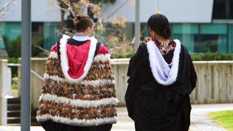 Graduates wearing academic regalia and a korowai.
