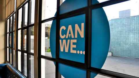 Window with a large decal reading "Can we..."
