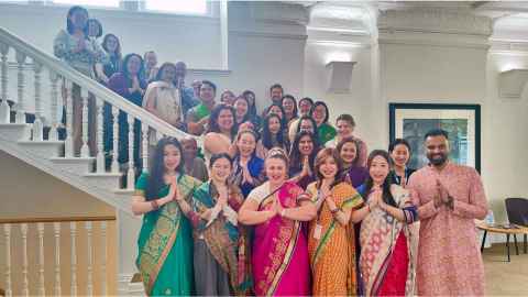 Group of people on the staircase dressed for Diwali. 