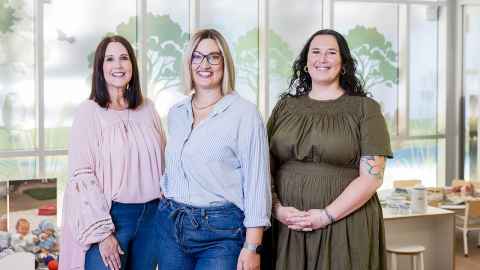 Three wahine, who are a part of the Early Childhood Services team smiling at the camera