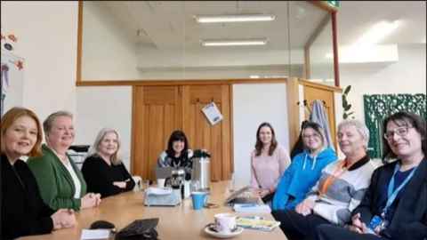 University Executive Assistants sitting around a table