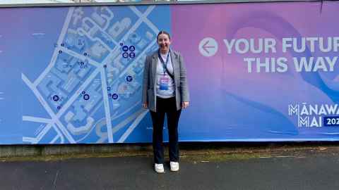 A woman in front of a colourful hoarding