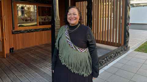 Photo of Dr Abigail McClutchie standing outside Ngā Tauira Marae. 