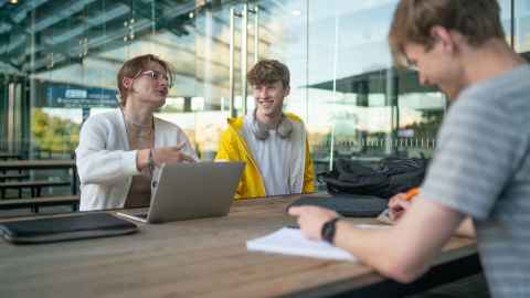 Photo of students sitting at the Owen G Glenn building atrium. 