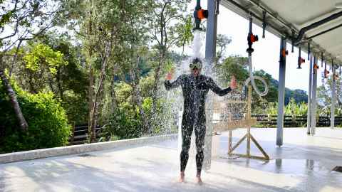 Photo of Andrew Reid in his scuba gear washing off under the shower.