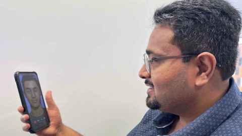 Photo of Kunal Gupta holding a cellphone. 