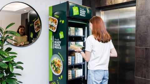 Photo of a woman choosing food from the My Food Bag vending machine. 