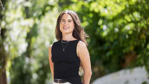 Hannah Taniwha wearing black with a green, sunny background