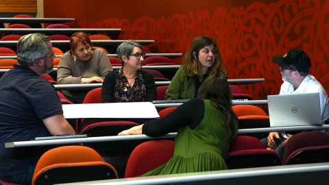 Photo of staff in a lecture theatre engaged in a deep discussion.