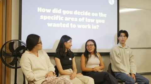 Four Asian students sitting in front of a screen with the words ' How did you decide on the specific area of law you wanted to work in?'.