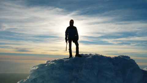 Mountaineer standing on a mountain in silhouette