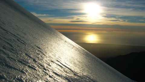 sun shining on an icy mountainside
