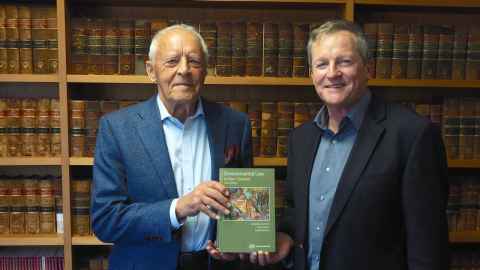 Two men holding a book.