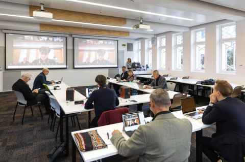 People in a classroom watching screens.
