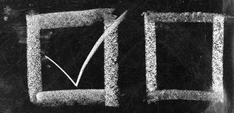 White chalk drawing of voting check mark and boxes on black background